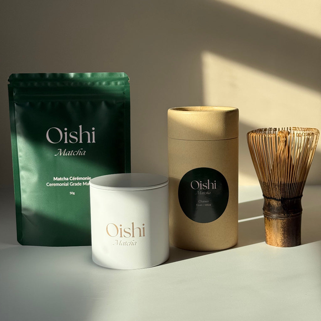 Ensemble comprenant le sachet Oishi Matcha de 50g, une boîte de stockage blanche avec logo doré et un fouet